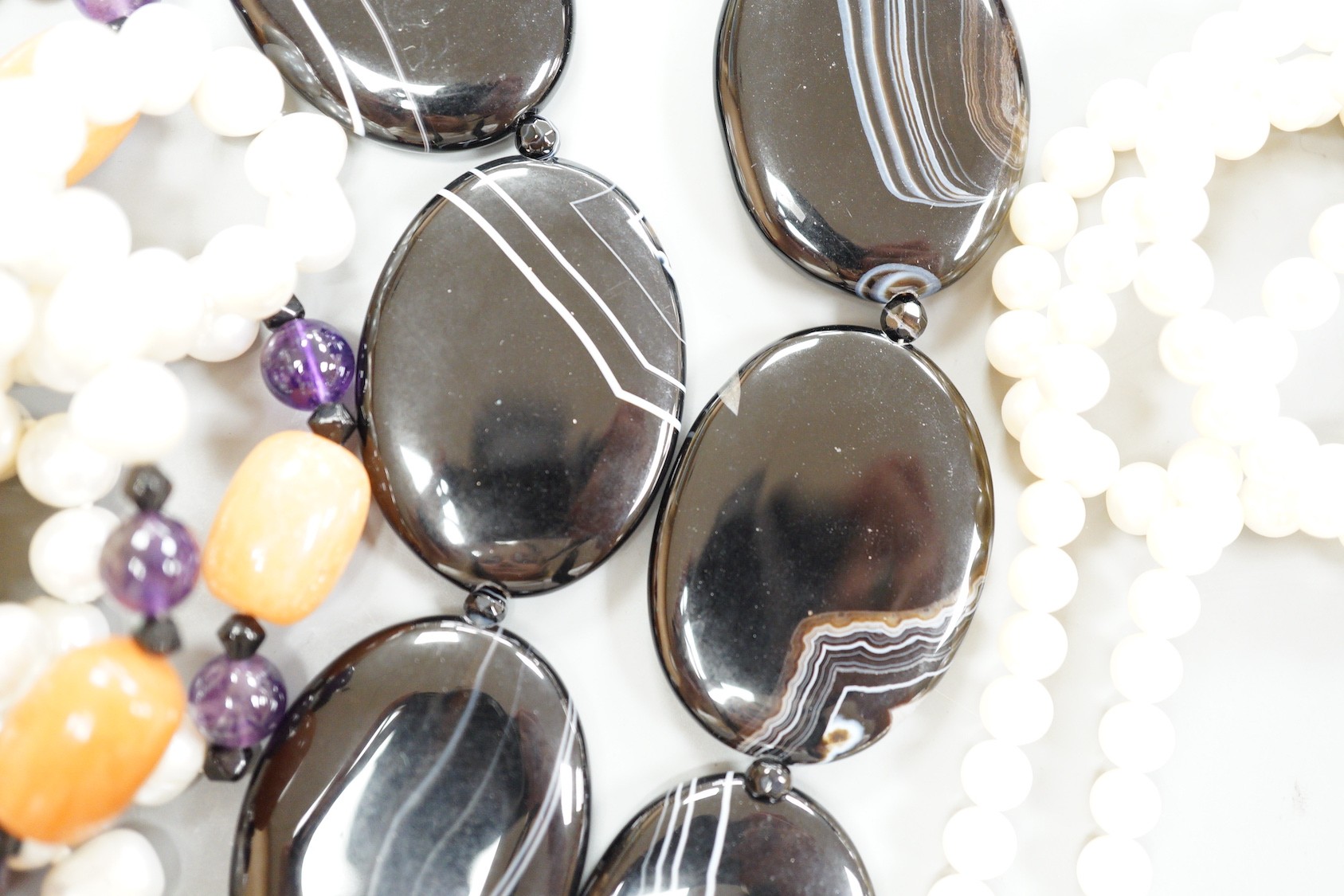 A double strand freshwater pearl necklace, with marcasite set clasp, a banded black agate necklace with 925 clasp and freshwater pearl, amethyst and agate set necklace.